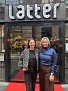 To kvinner poserer på rød løper foran inngangsdøren til Latter i Oslo